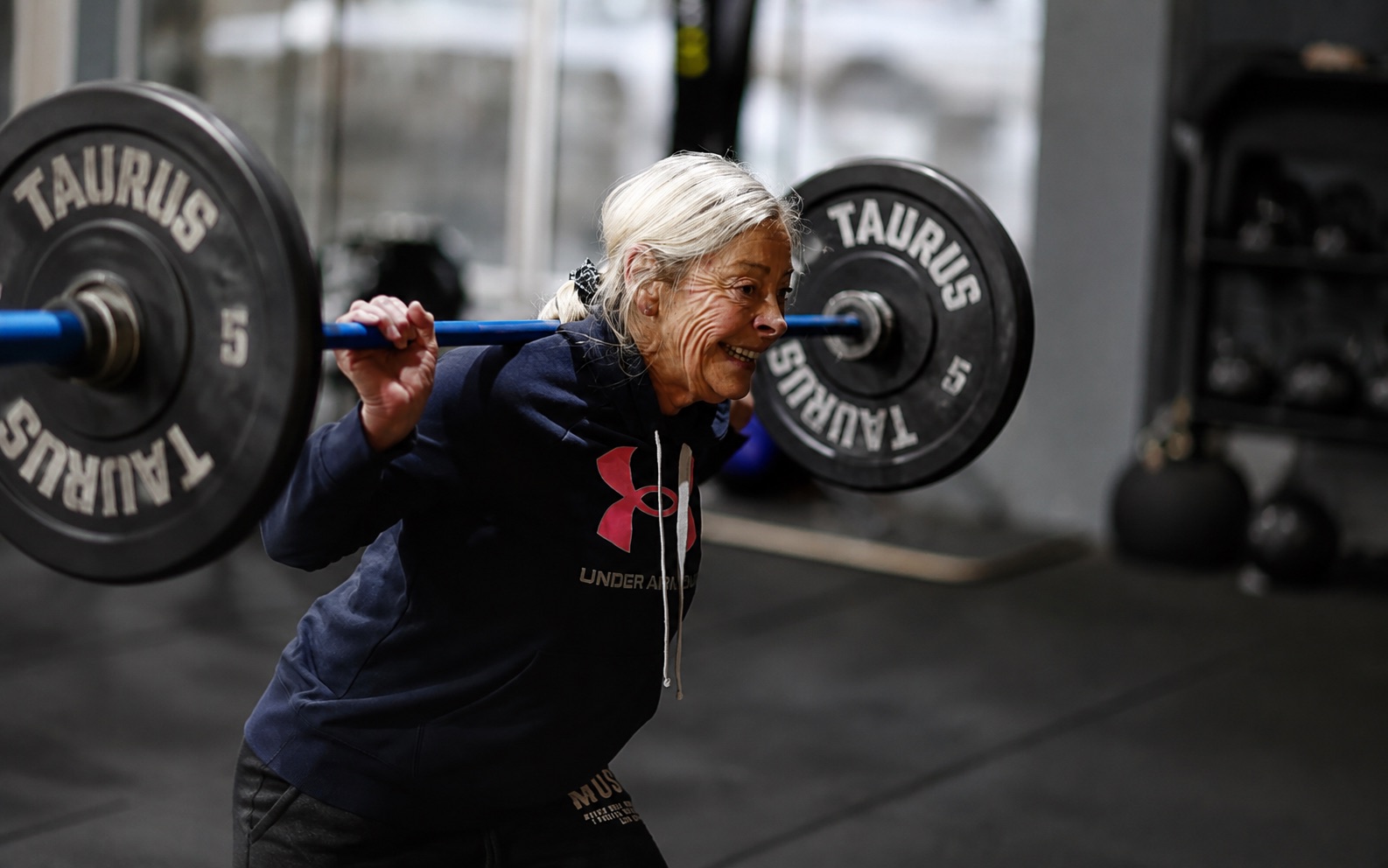 Atleta de Garage Box haciendo sentadilla con barra en clase de CrossFit adultos